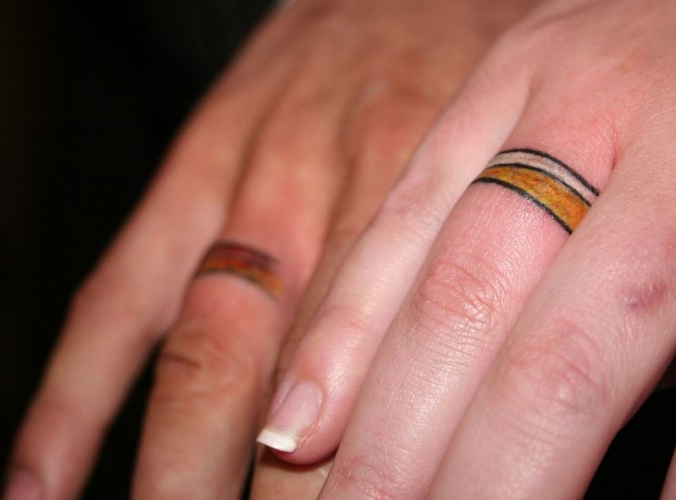 Черные полосы от золотого кольца. Тату обручальные кольца. Тату в виде обручального кольца. Тату обручальные кольца на пальцах. Золотая тату обручальное кольцо.